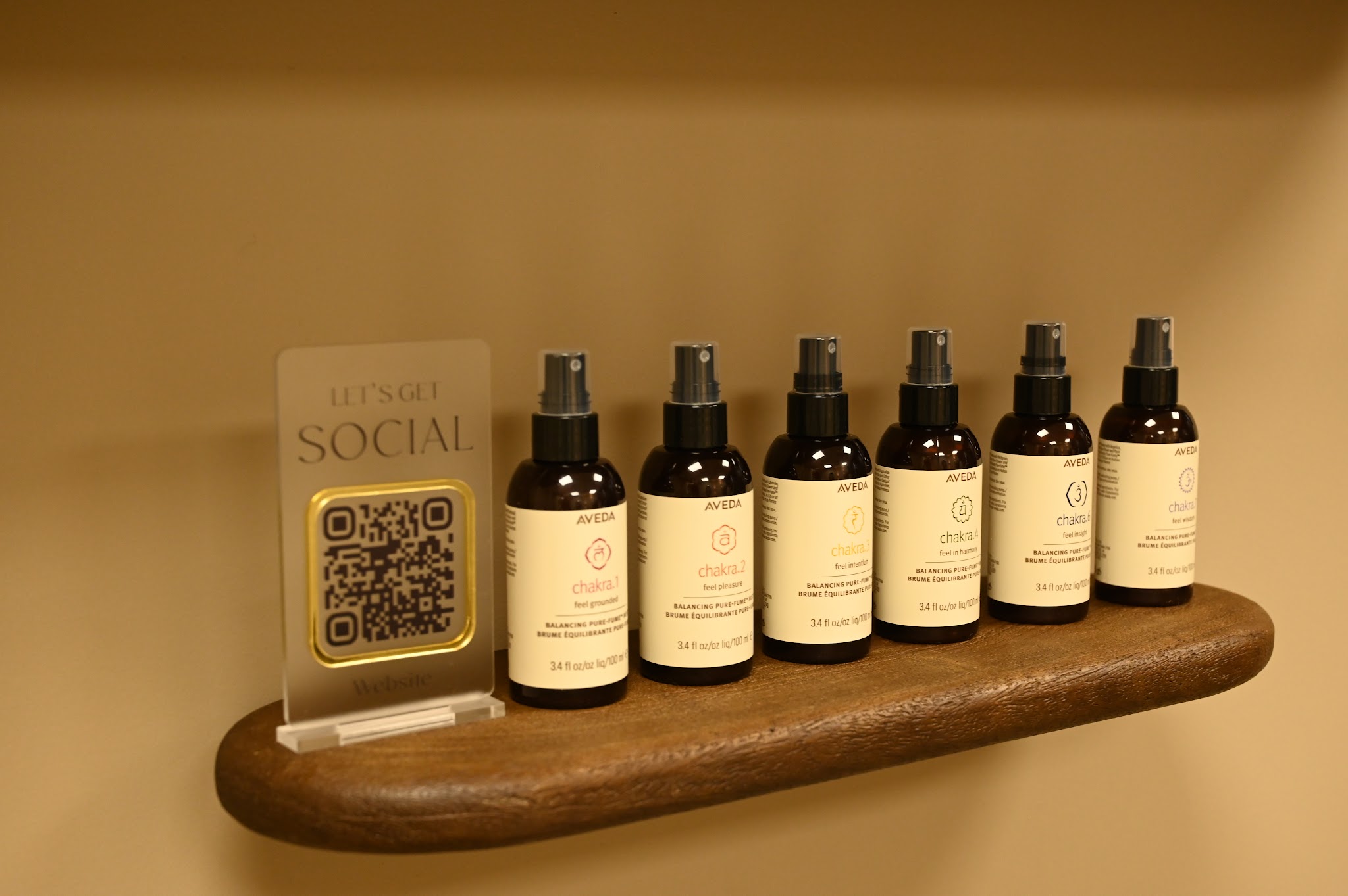 Zes flesjes Aveda mist op een houten plank aan de muur